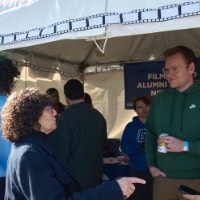 Suzanne Zack talking to people at the Film/Video Alumni Affinity Network tent